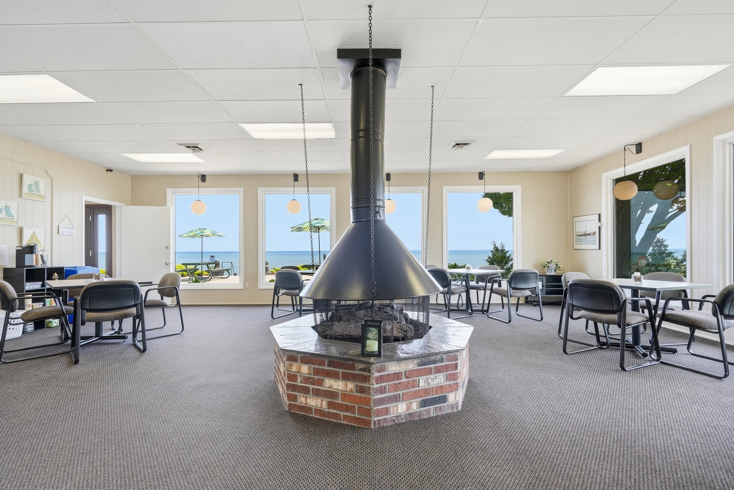 Community center fireplace lounge with panoramic Lake Huron views